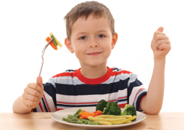 Enfant mangeant une assiette de légumes